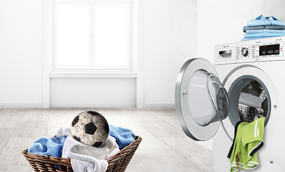 Bosch washing machine with clothing and dirty football