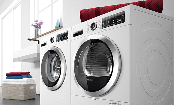 Two tumble dryers side by side with laundry