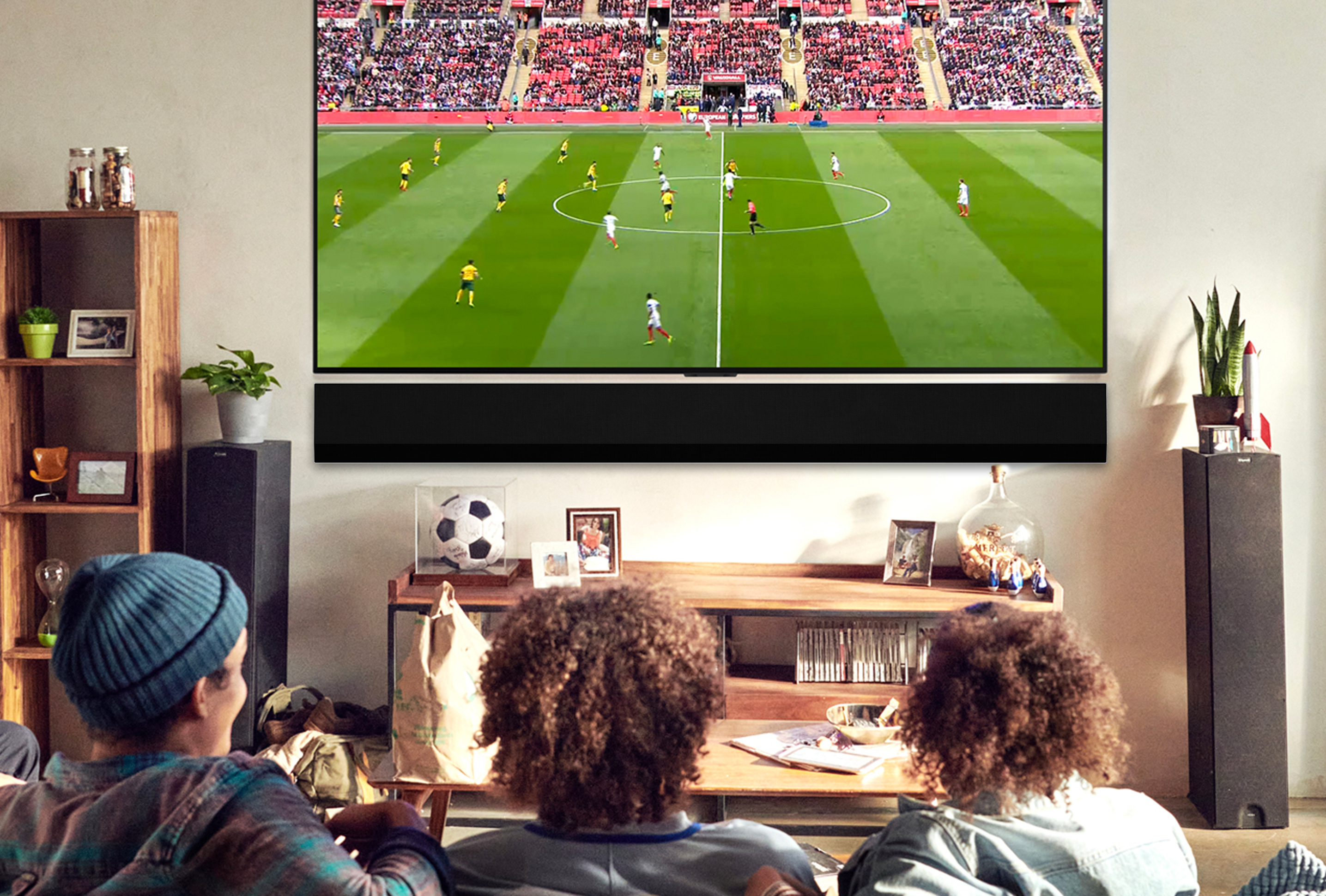 A group of men watch the football on a tv