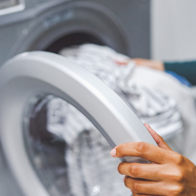 Woman putting clothes in a washing machine