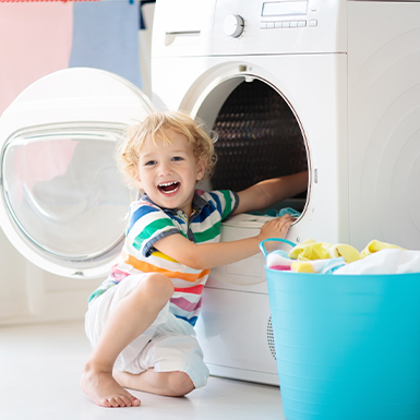 Child playing with washer dryer