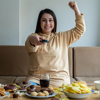 Woman watching sports with snacks