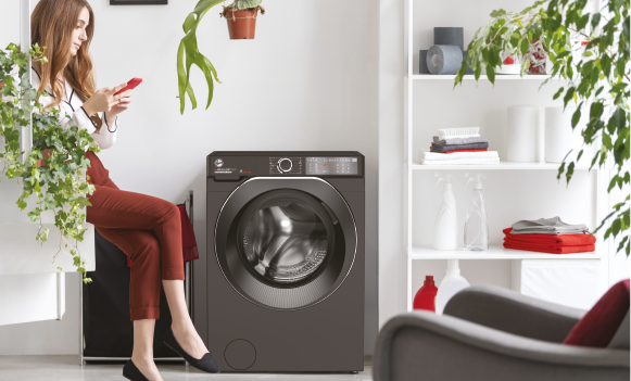 a women is on her phone next to washing machine